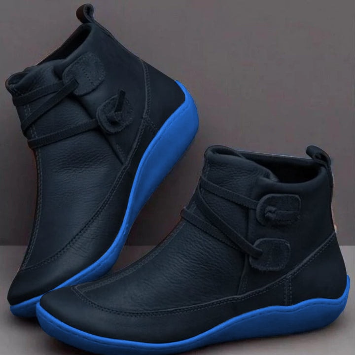 Black ankle boots with bright blue soles, adjustable side straps, rounded toes, rear pull tabs, and stitched panels shown from two angles.