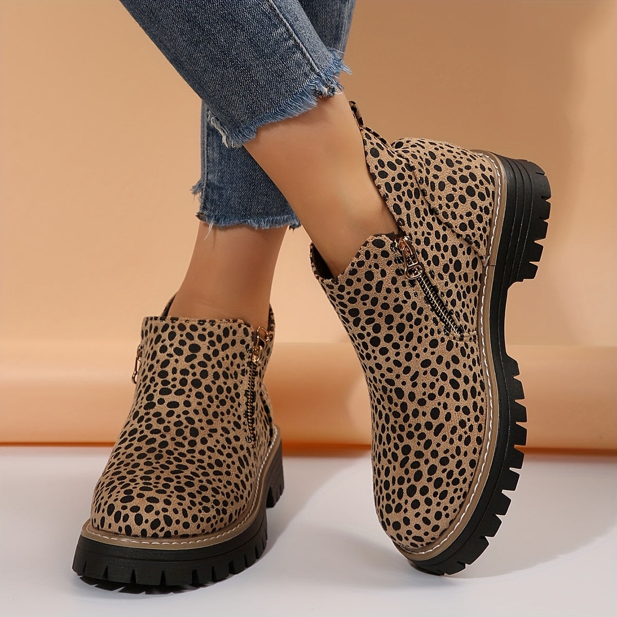 Leopard-print ankle boots shown on feet, highlighting the chunky lug soles and contrasting stitching.