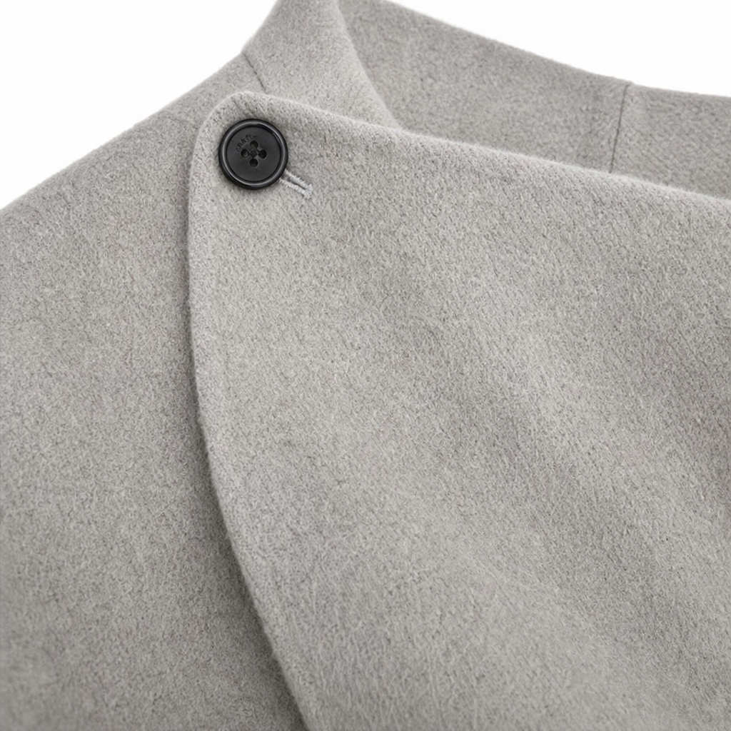 Detail of the jacket’s buttoned collar and overlapping wrap front in light gray.