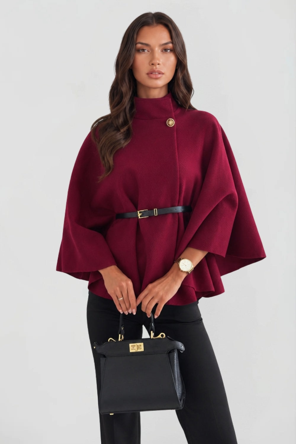 Burgundy cape jacket shown from a slightly angled front view, highlighting its oversized drape and waist-defining belt.