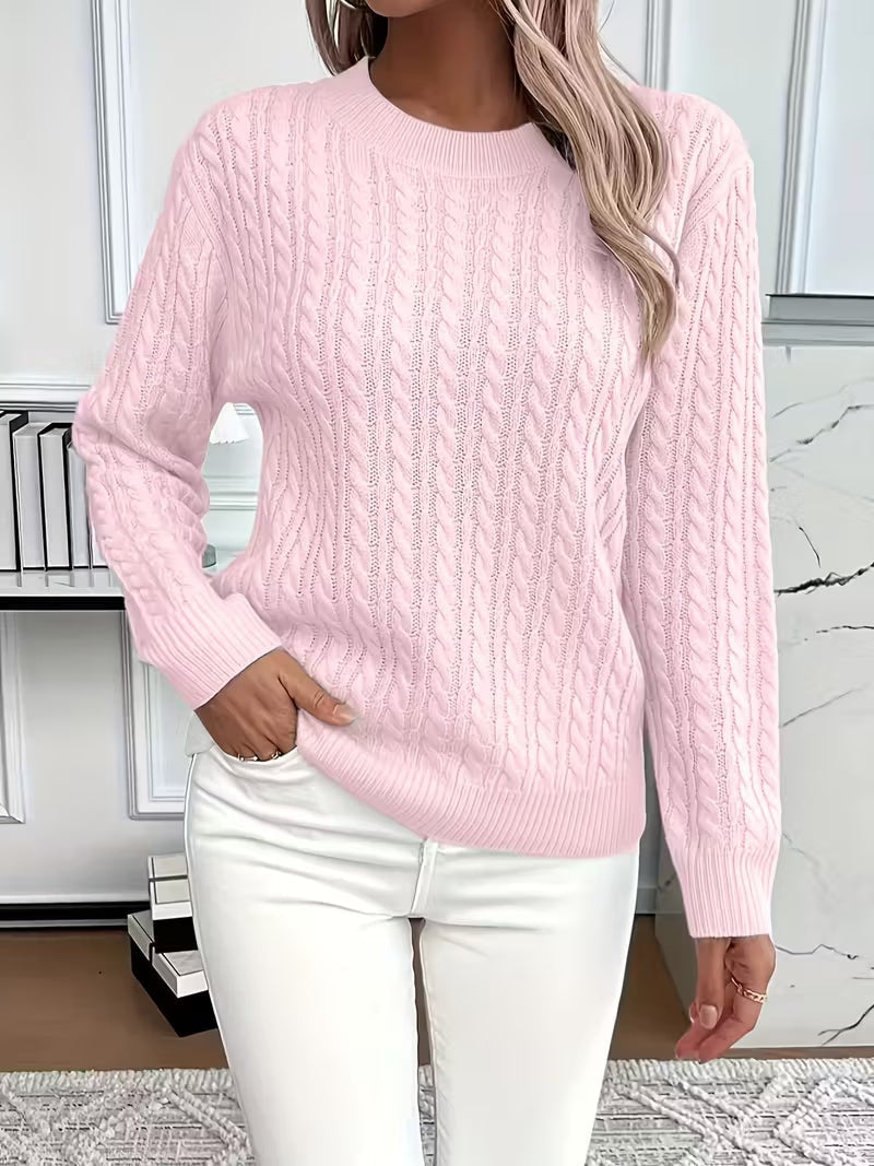 Light pink cable knit crew neck sweater with ribbed trims and long sleeves, paired with white jeans.