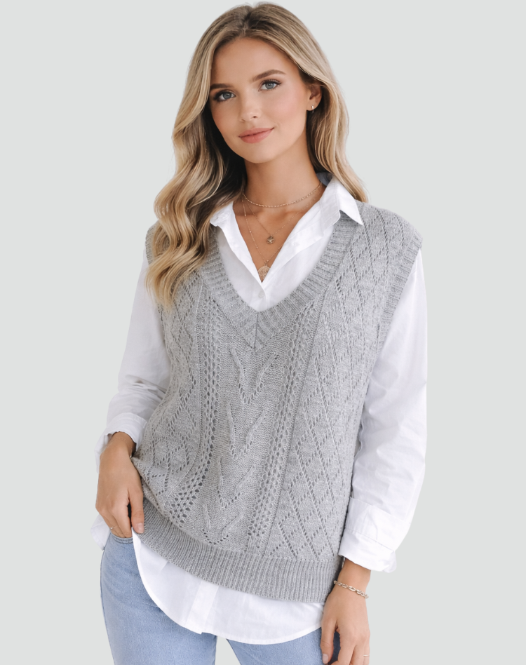 Gray cable knit V-neck sweater vest styled over a white collared shirt, shown from the front with textured vertical patterning and ribbed edging.