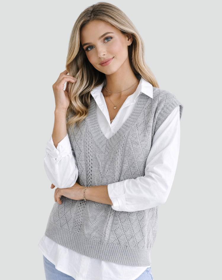 Gray cable knit sweater vest shown in a closer front view, emphasizing the V-neckline, sleeveless layered design, and ribbed neckline and hem.