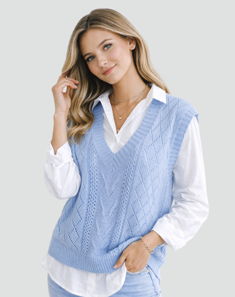 Light blue cable knit V-neck sweater vest layered over a white shirt, shown from the front with a textured pattern and relaxed silhouette.