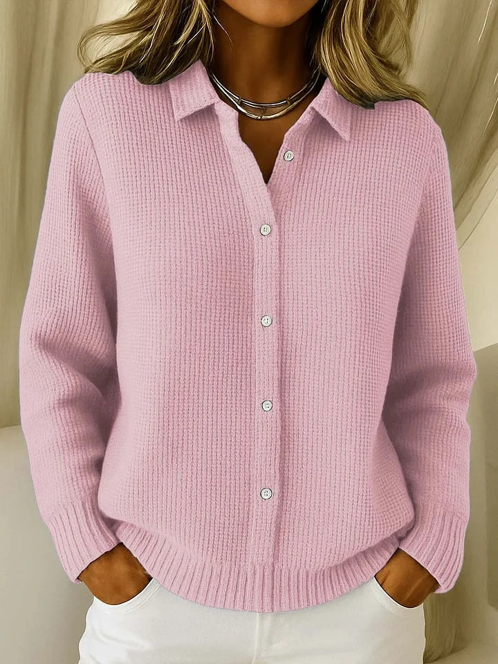 Soft pink collared cardigan shown fastened with front buttons, long sleeves, ribbed cuffs, and a gently curved hem.