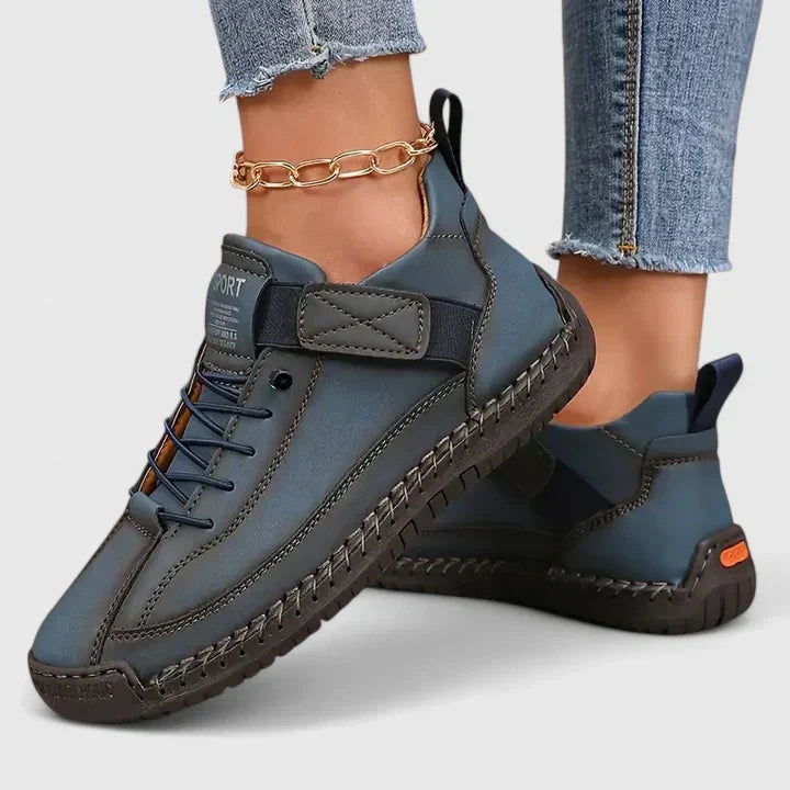 Blue-gray sneakers with dark outsoles, lace-up fronts, ankle straps, and rear pull tabs.