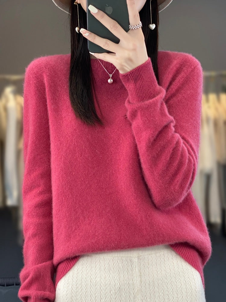 Berry pink crew neck sweater with a relaxed fit, long sleeves, and ribbed cuffs over a light patterned bottom.