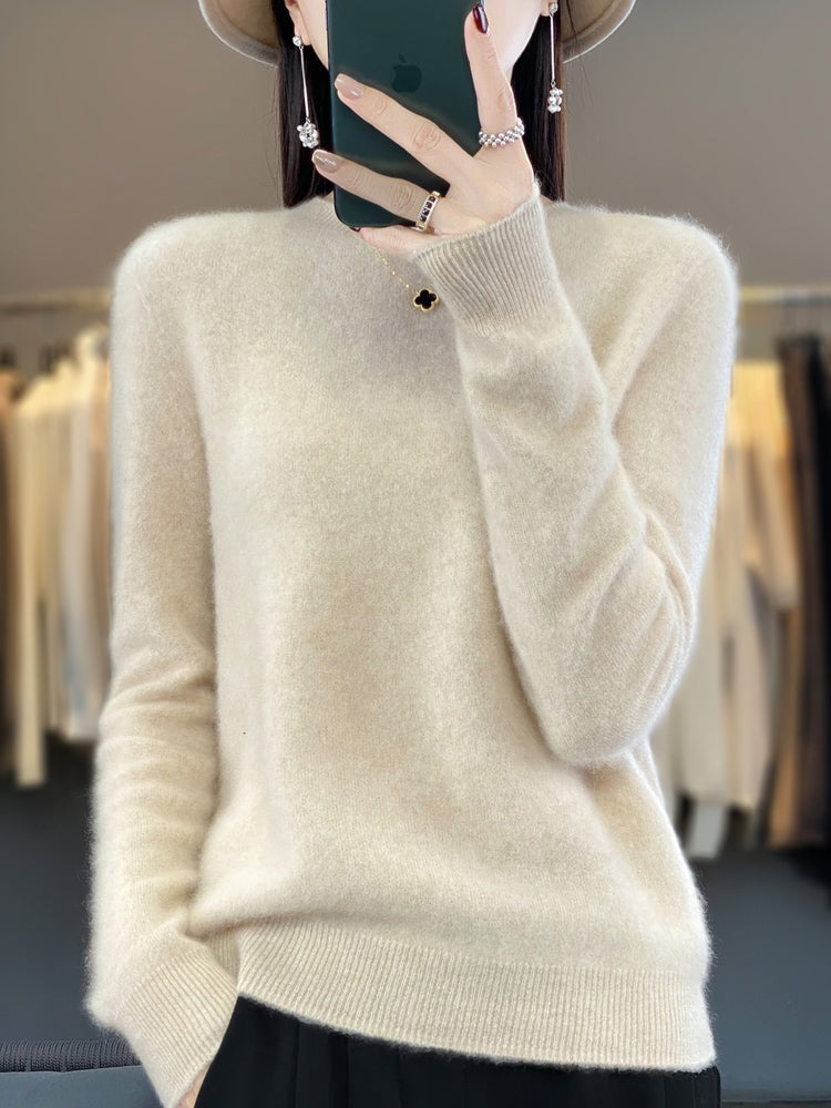 Cream crew neck sweater with a straight ribbed hem and cuffs, paired with black trousers.