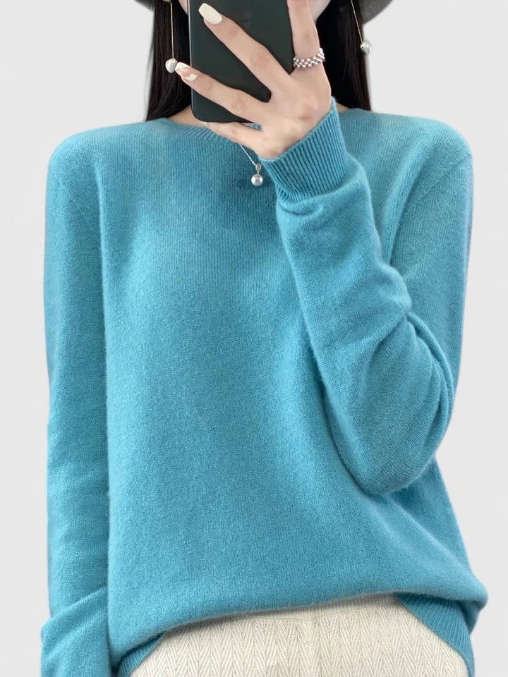 Light turquoise crew neck sweater presented against a plain background, showing its relaxed body and long sleeves.