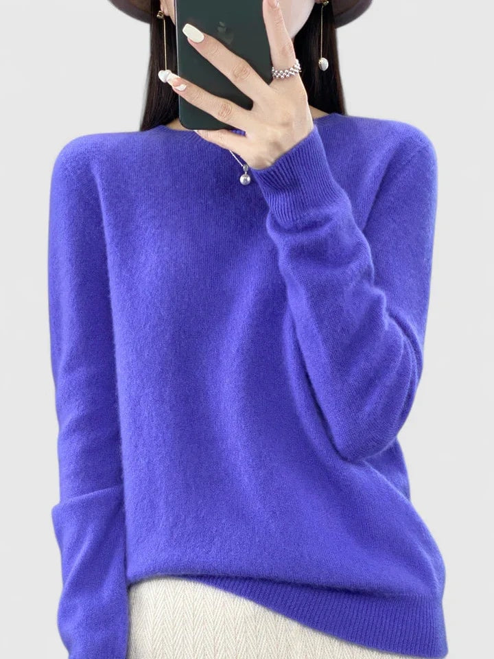 Bright violet crew neck sweater against a plain background, showing its long sleeves and ribbed cuffs.
