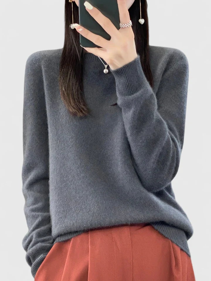 Charcoal gray crew neck sweater against a plain background, paired with rust-colored trousers.