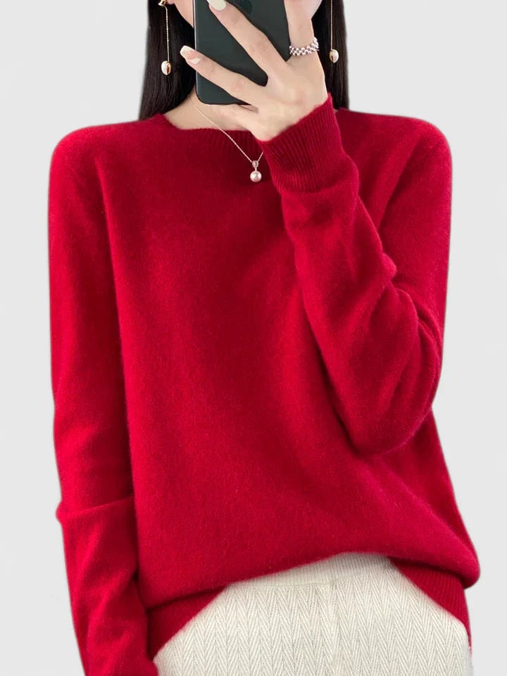 Vivid red crew neck sweater against a plain background, showing its long sleeves and ribbed cuffs.