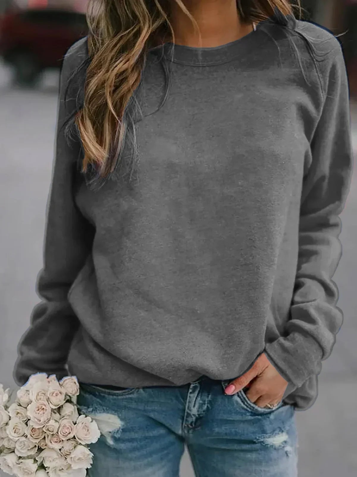 Gray women's crew neck sweatshirt with a relaxed silhouette, raglan sleeves, and ribbed hem.