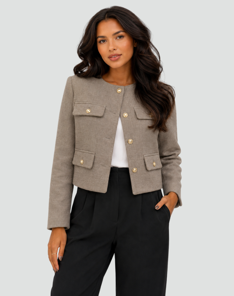 Front view of the brown cropped collarless blazer closed with long sleeves, gold-tone buttons, and four flap pockets.