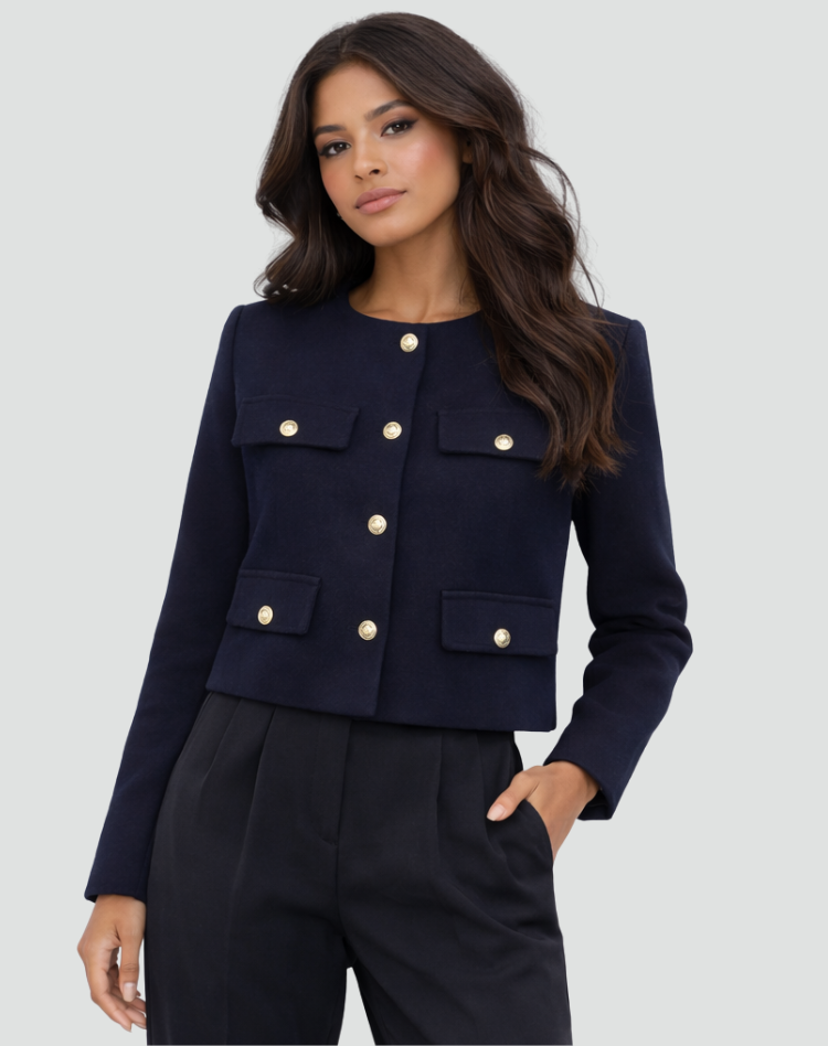 Front view of the navy cropped collarless blazer closed, with gold-tone buttons and four flap pockets.