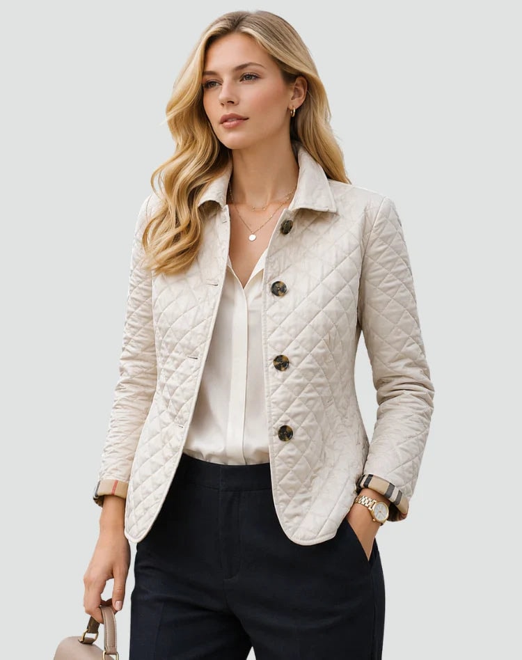 Ivory diamond-quilted jacket with a contrasting shirt collar, dark buttons, long sleeves, and rounded front pocket openings, worn with dark trousers.