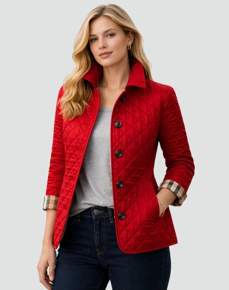 Bright red diamond-quilted button-front jacket with a raised collar, long sleeves, and side pockets, styled over a gray top and jeans.