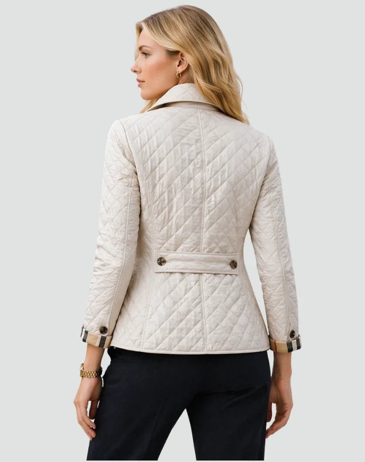 Back view of the ivory diamond-quilted jacket showing the full diamond stitching, long sleeves, shirt collar, and a horizontal buttoned waist detail.
