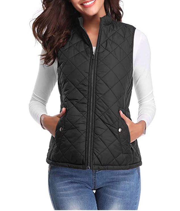 Black quilted zip-up vest with sleeveless cut and front pockets, worn over a white long-sleeve shirt.