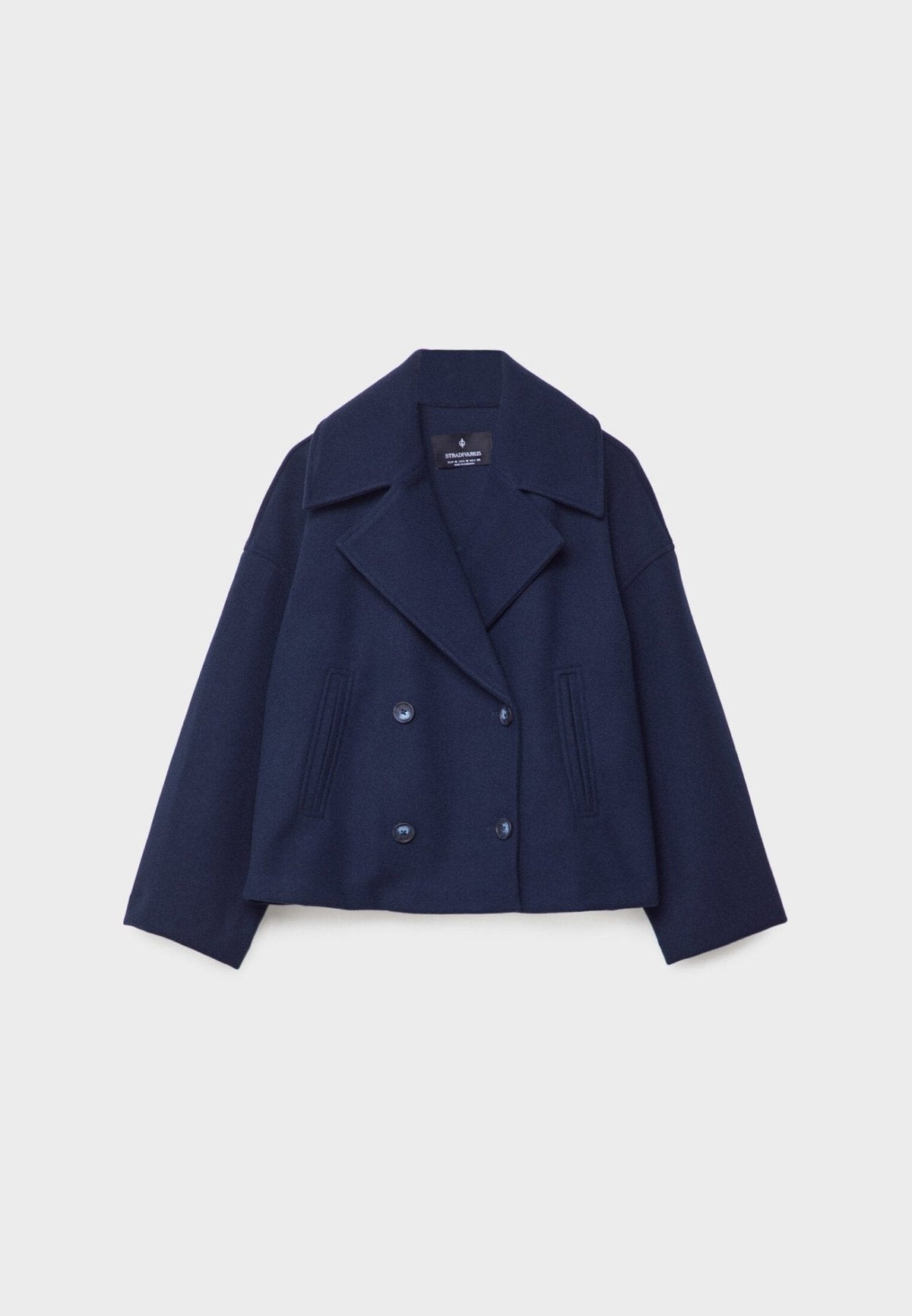 Navy cropped jacket shown flat from the front with a double-breasted button arrangement and long sleeves.