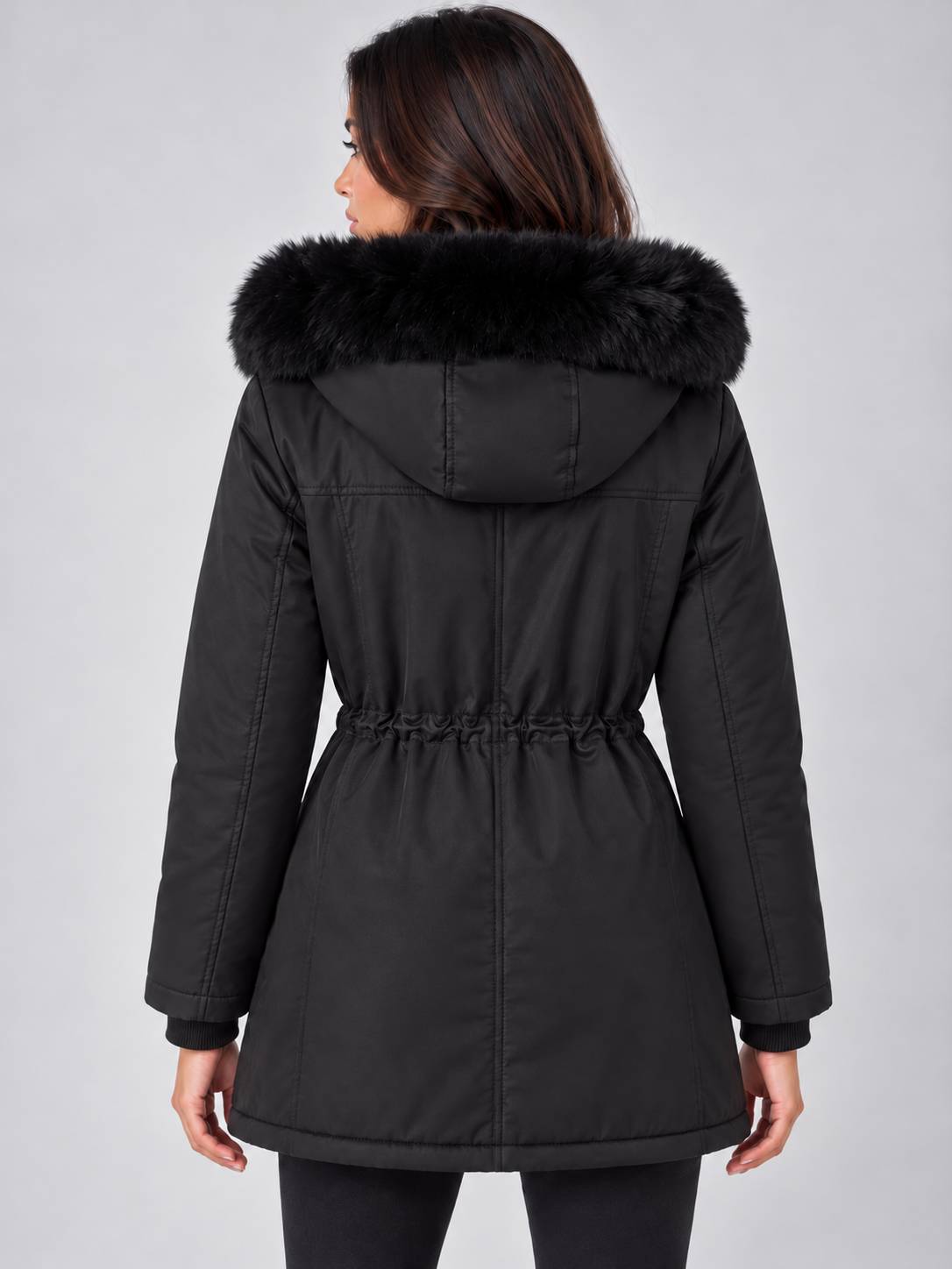 Back view of the black winter parka showing its long covered silhouette, hood, and gathered adjustable waist.
