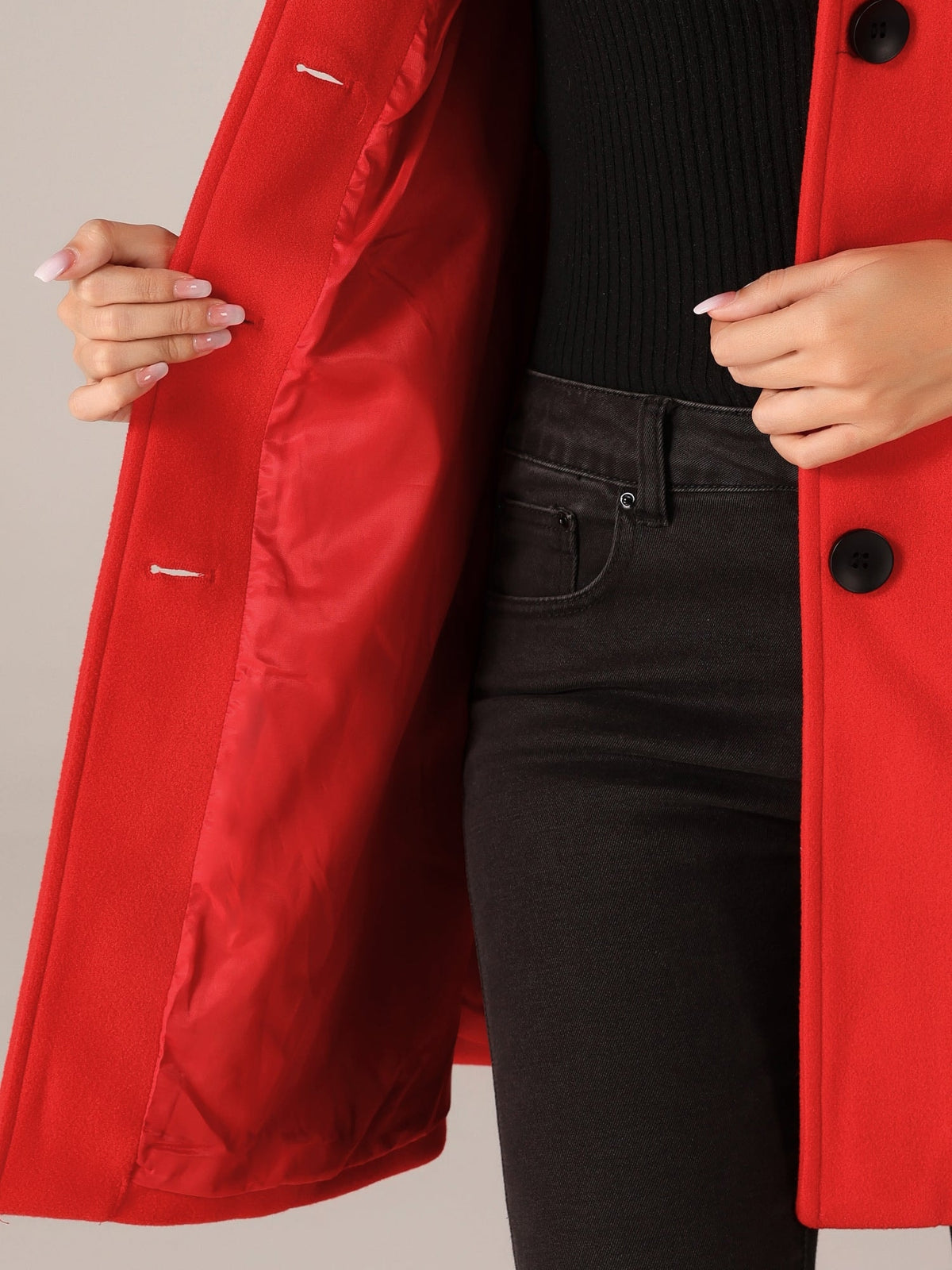 Close-up of the open red coat showing its smooth lining, button placket, and front fastening details.