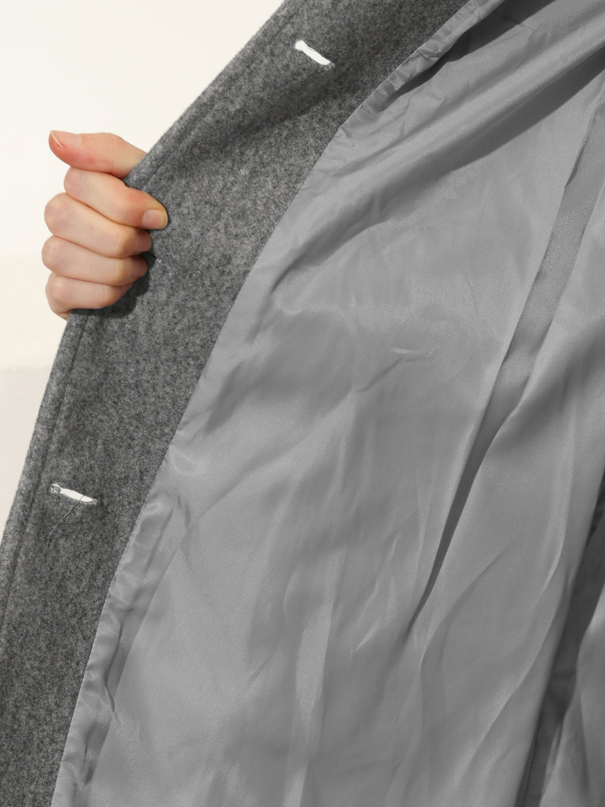 Close-up of the gray coat interior, showing the smooth lining and concealed inside fastening details.
