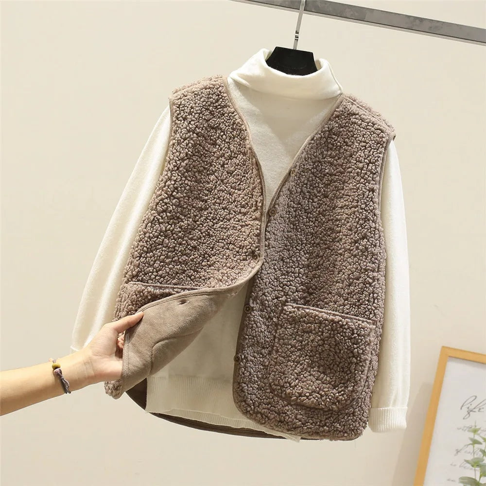 Taupe fleece vest shown over a white turtleneck, with the front panel lifted to display the smooth inner side and button fastening.