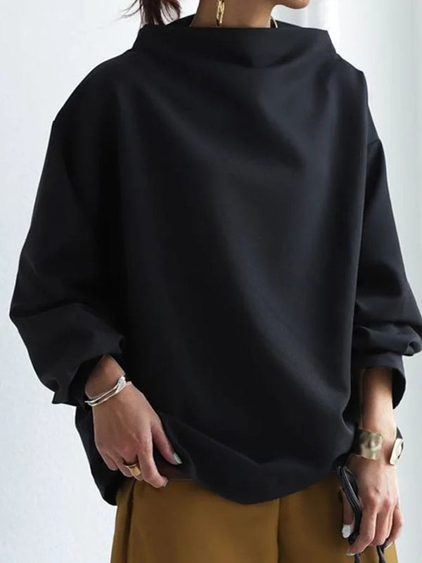 Close front view highlighting the high neckline, smooth solid black design, and softly gathered sleeve cuffs.