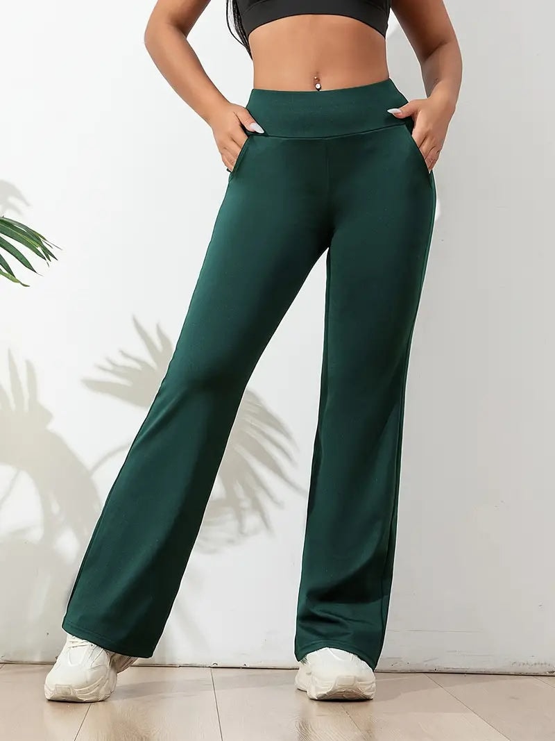 Deep green flared activewear pants displayed with the waistband and relaxed leg shape clearly visible.
