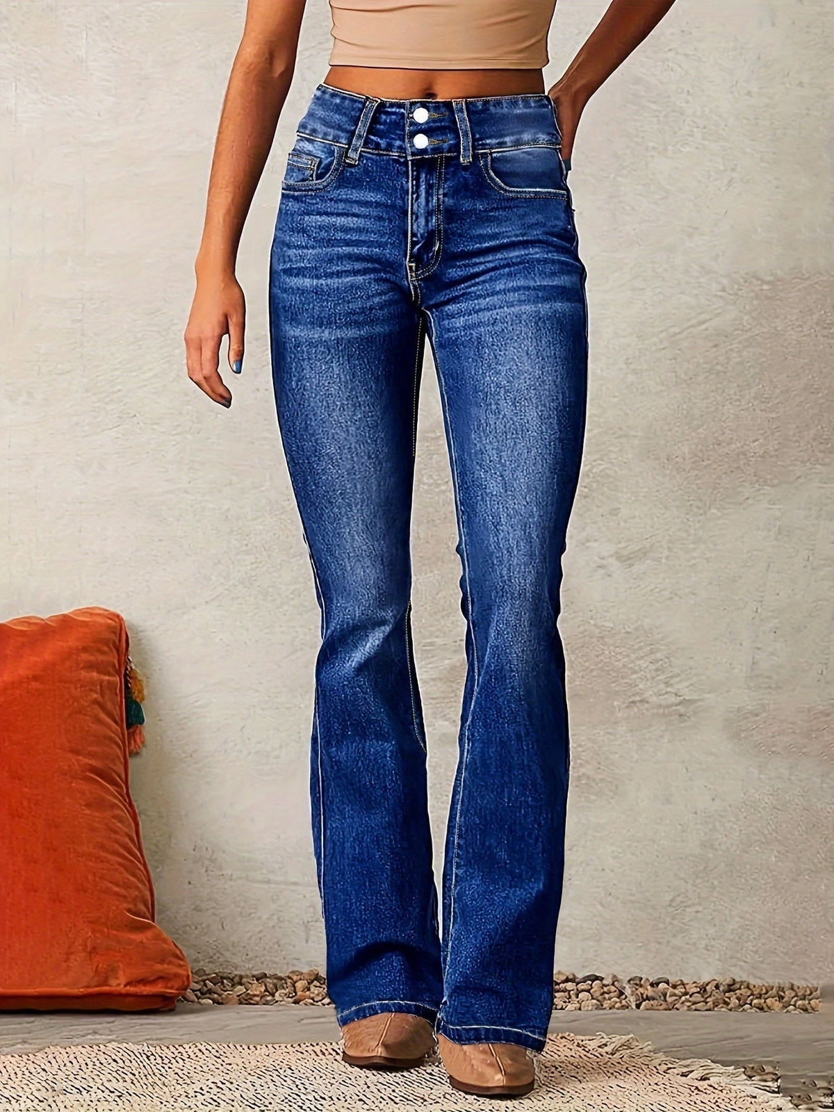 Front view of dark blue high-waisted flared jeans showing the defined waistband, front closure, and full-length flared legs.