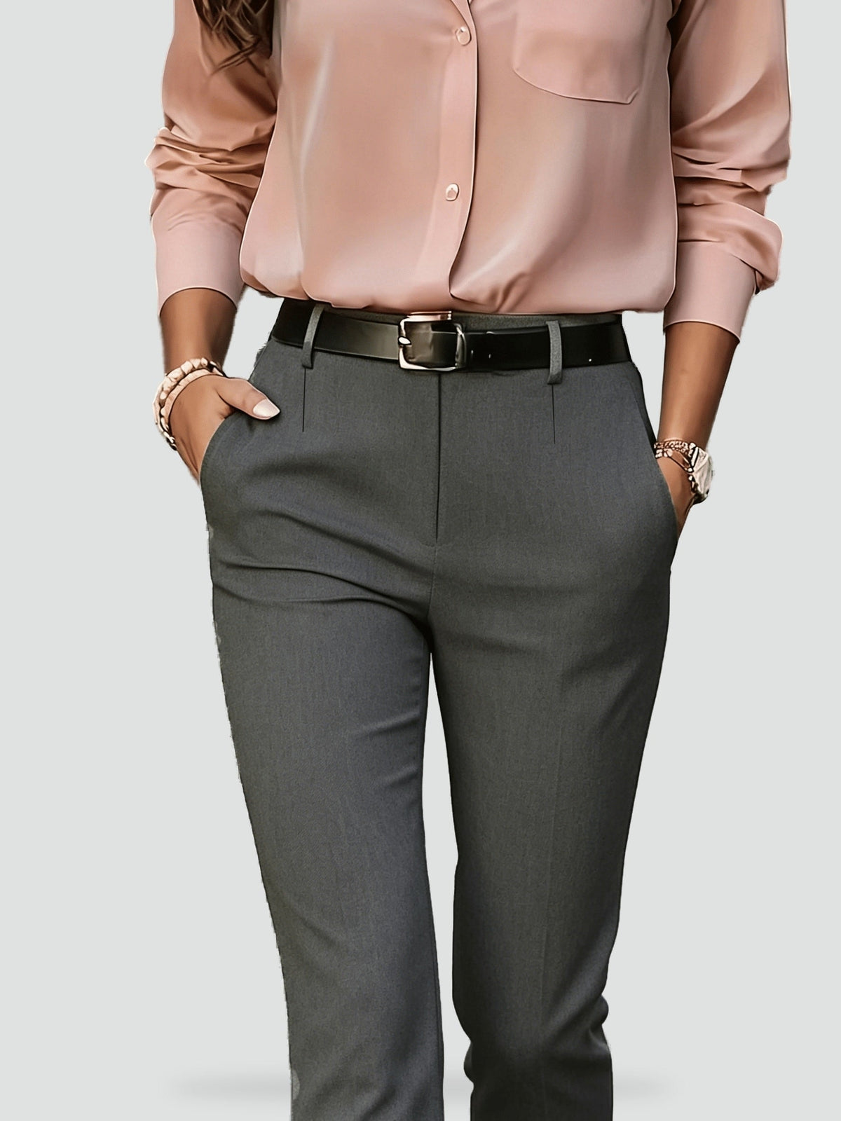Close-up front view of gray slim-fit trousers showing the tailored waist and slanted side pockets.