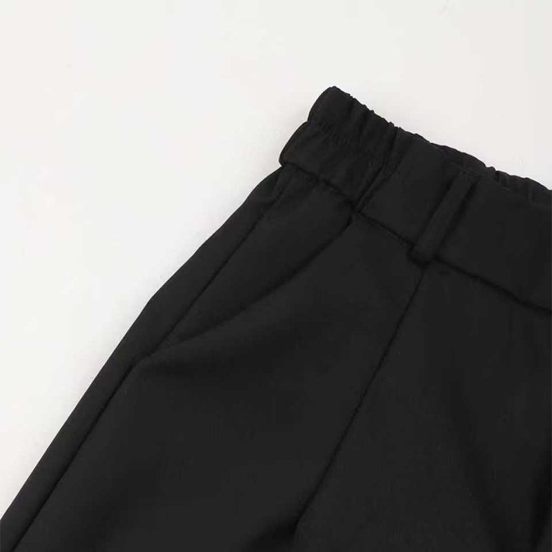 Close-up of black trouser waistband showing belt loops, a side pocket opening, and tailored pleat stitching.