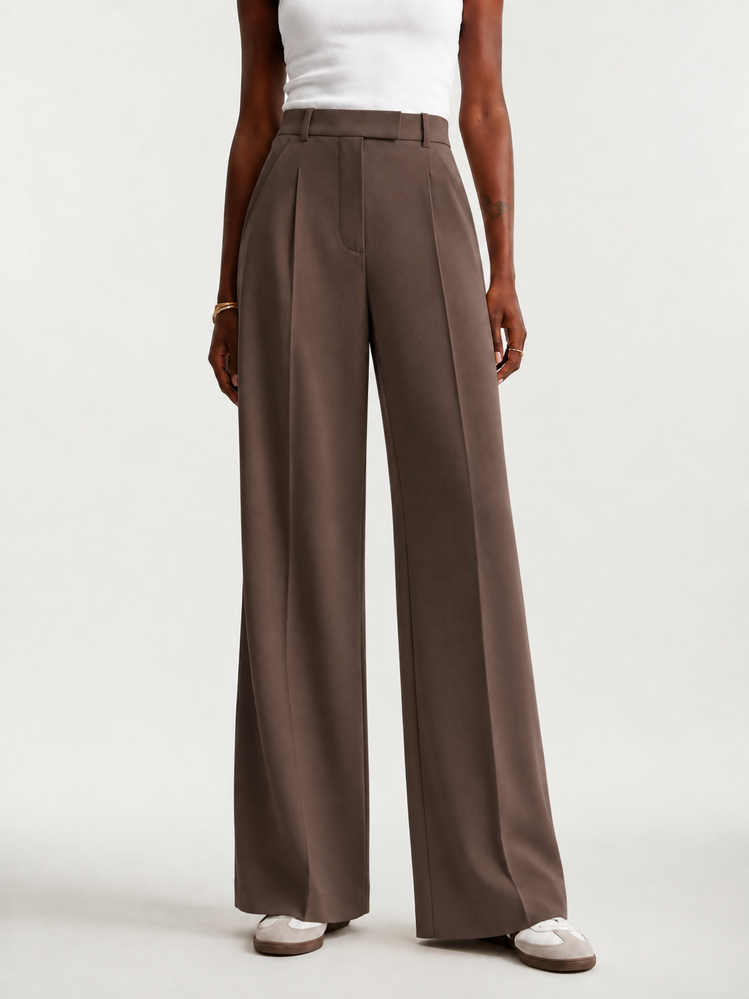 Front view of deep brown full-length trousers with a high waist, tailored pleats, and wide legs.