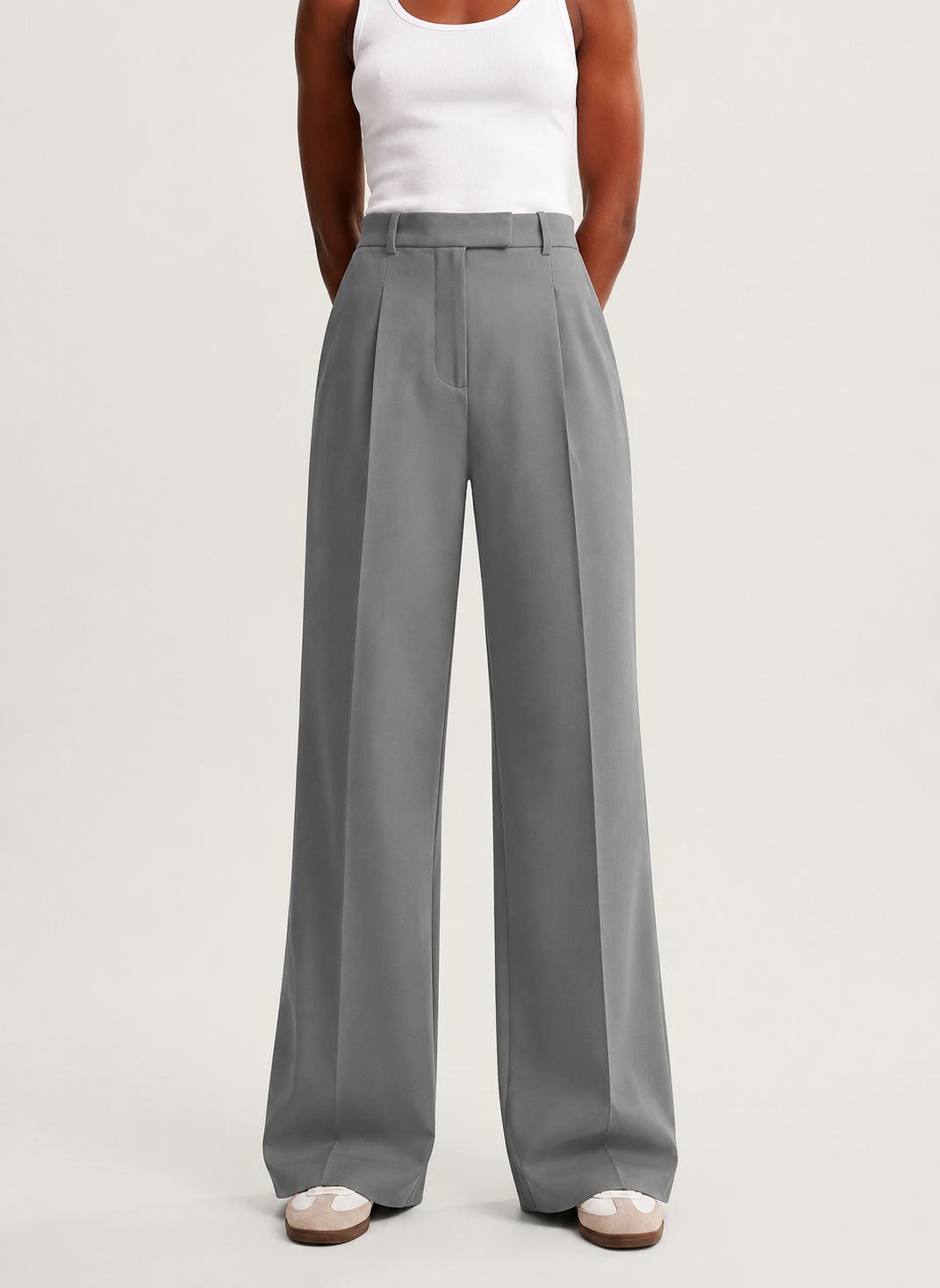 Front view of gray high-waisted trousers with front pleats, belt loops, and long wide legs.