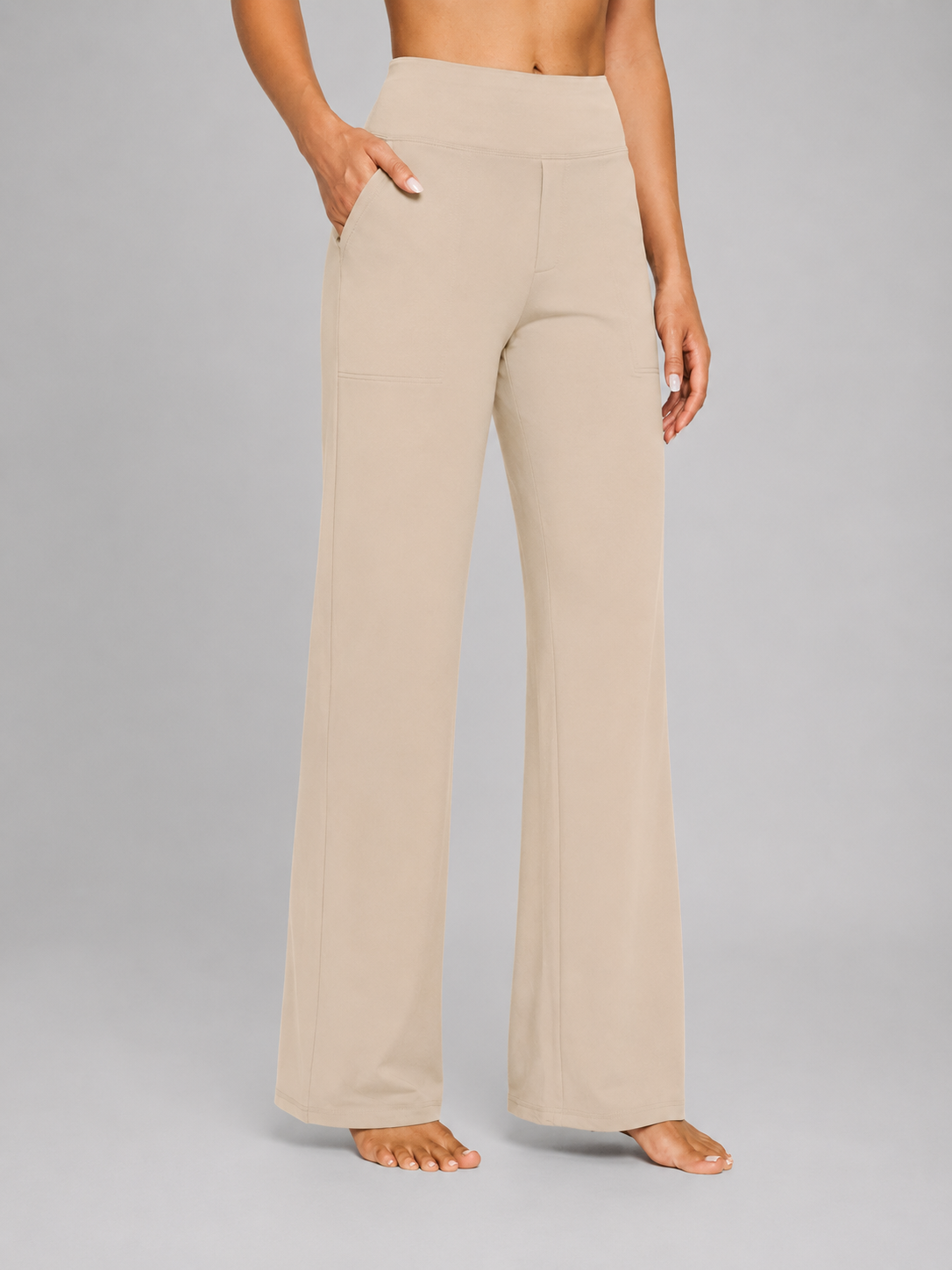 Front view of the wide-leg trousers in light beige, styled with a high waistband and side pocket.