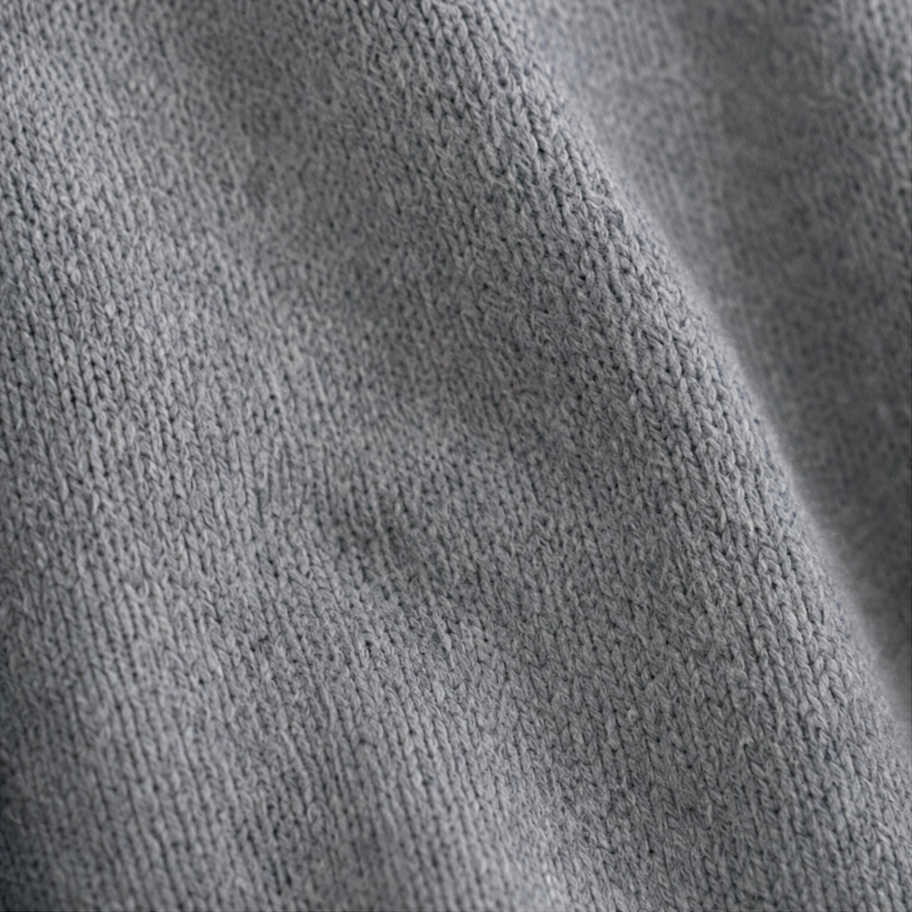 Close-up of the cardigan’s gray knitted surface and fine vertical stitch texture.