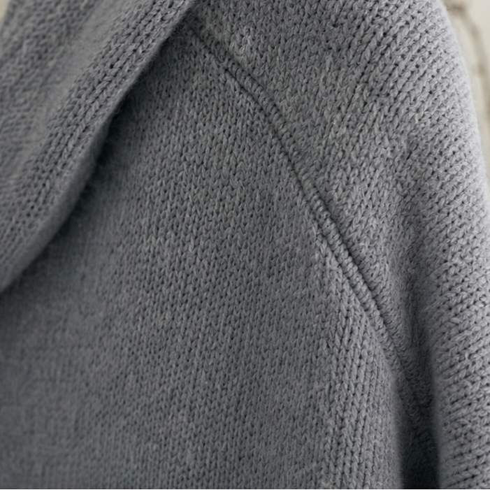 Detail of the gray cardigan’s hood seam and sleeve construction.