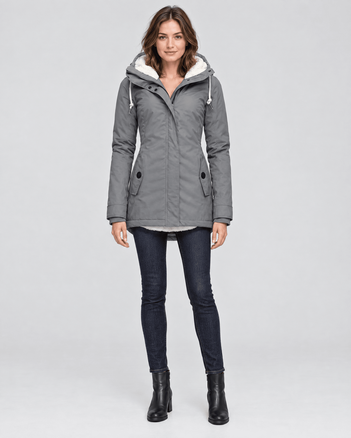 Front view of a gray hooded mid-length winter jacket with a lightly fitted shape, front zip closure, protective placket, and two angled pockets.