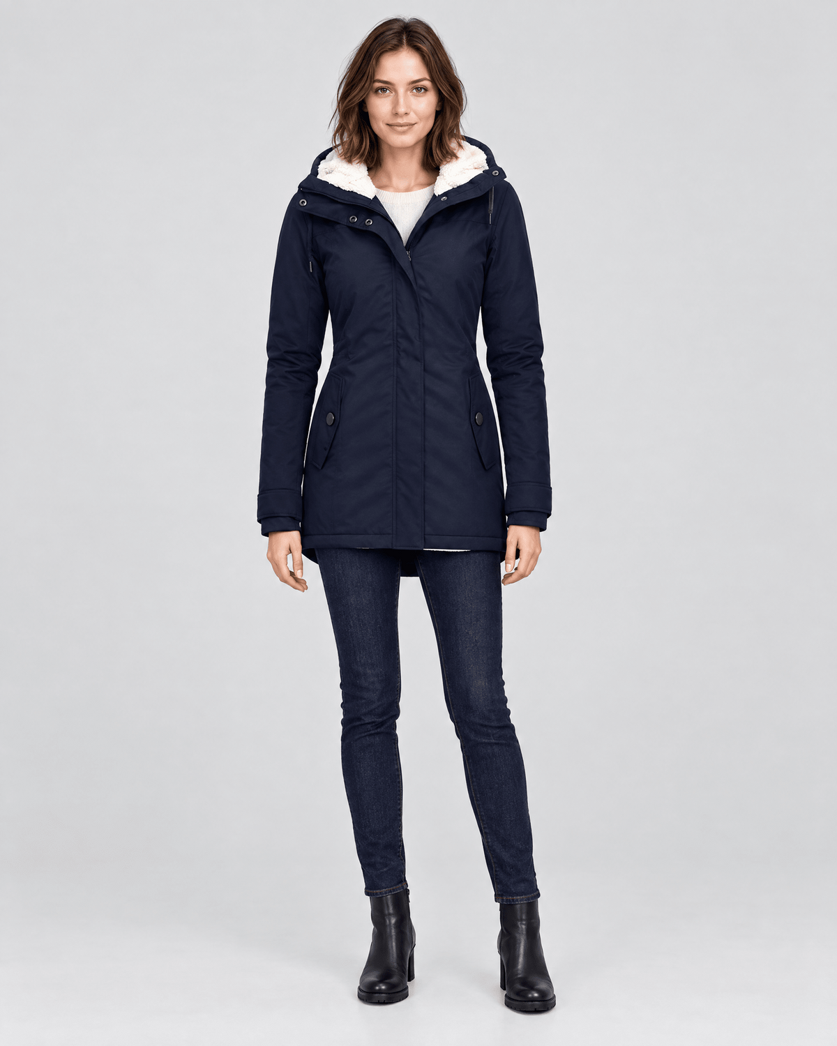 Front view of the navy hooded mid-length jacket worn with the hood open and two slim angled pockets.