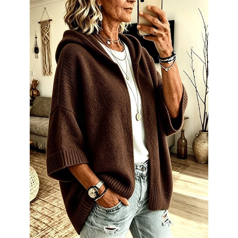 Brown hooded open-front cardigan styled over a white top, shown from a three-quarter front view with three-quarter sleeves and ribbed cuffs.