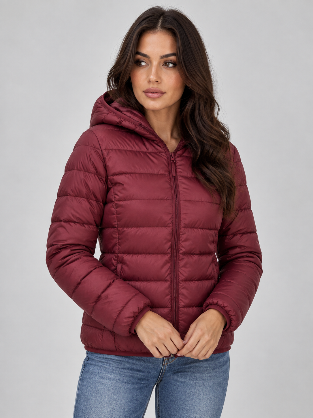 Front view of the hooded quilted puffer jacket in burgundy with horizontal quilting and the front zip partly open.