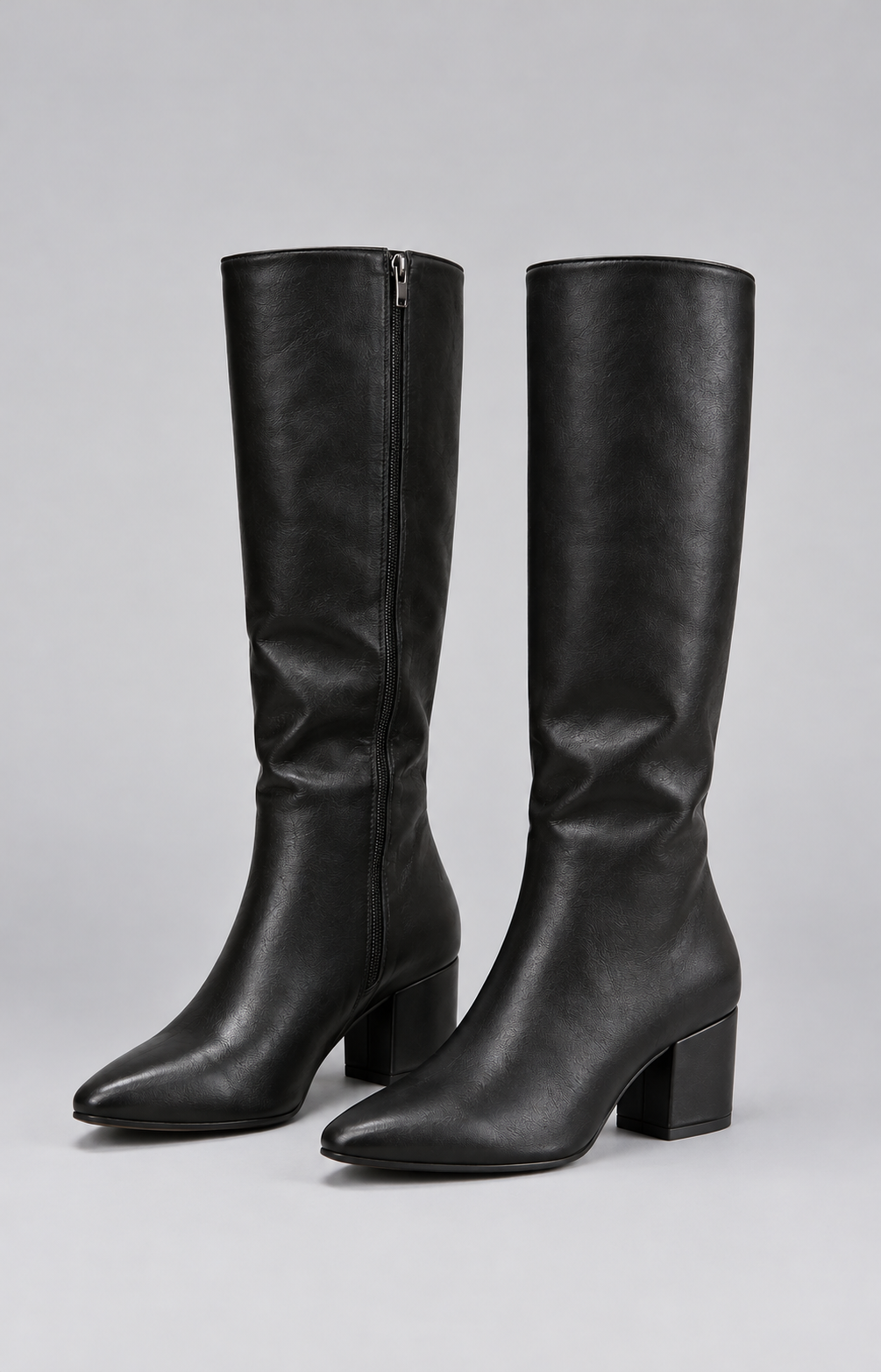 Pair of black knee-high boots with pointed toes, softly gathered shafts, side zips, and mid-height block heels shown standing together.