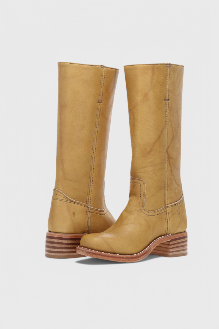 Pair of tan knee-high boots displayed together, showing contrasting stitched panels and layered low heels.