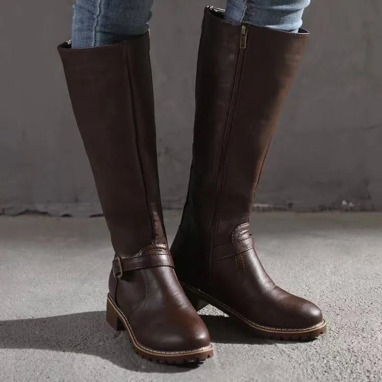 Dark brown knee-high riding boots displayed from the front and side, highlighting the ankle buckle, side zipper, and textured soles.