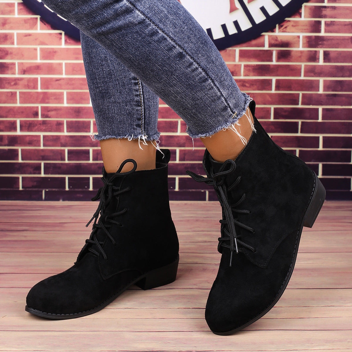 Pair of black ankle boots shown worn at a three-quarter angle, displaying the lace-up fronts and ankle-height shafts.