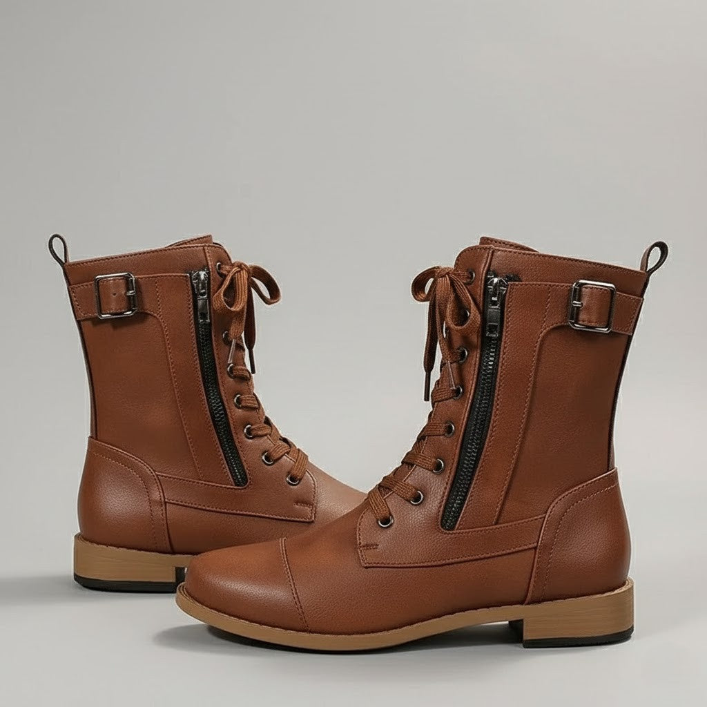 Three-quarter view of brown lace-up ankle boots highlighting the side zips, buckled straps, pull tabs, and stitched panels.