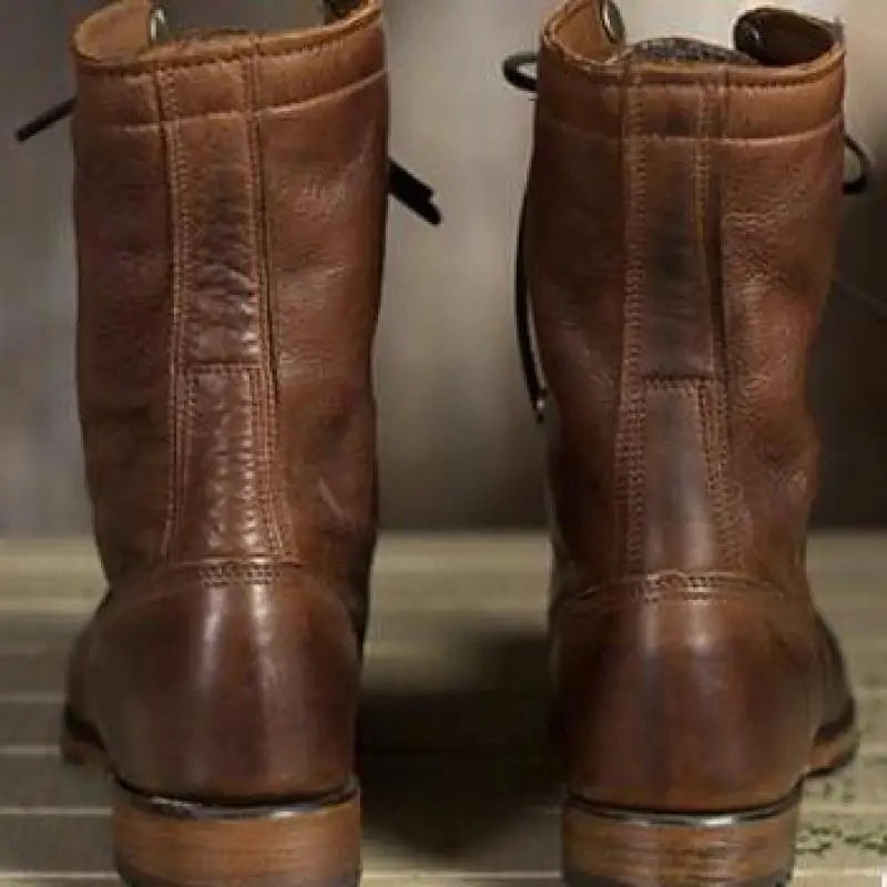 Rear view of the brown mid-calf boots, highlighting the tall shafts, stitched back panels, rounded heels, and textured outsoles.
