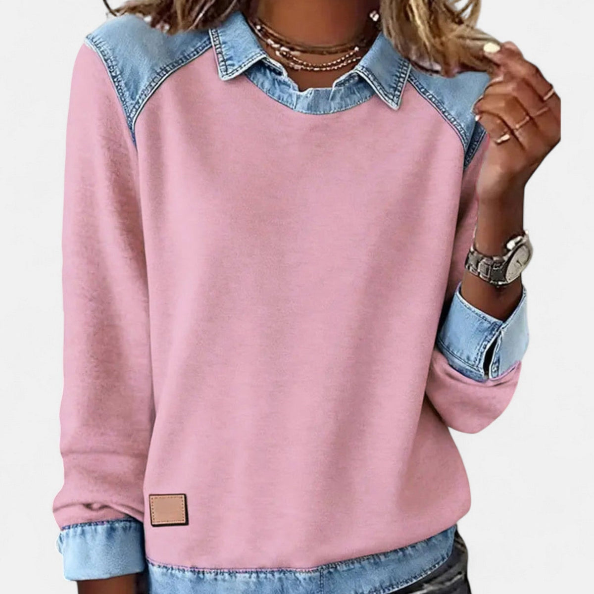 Front view of the pink sweater with contrasting blue collar, shoulder panels, cuffs, and hem.