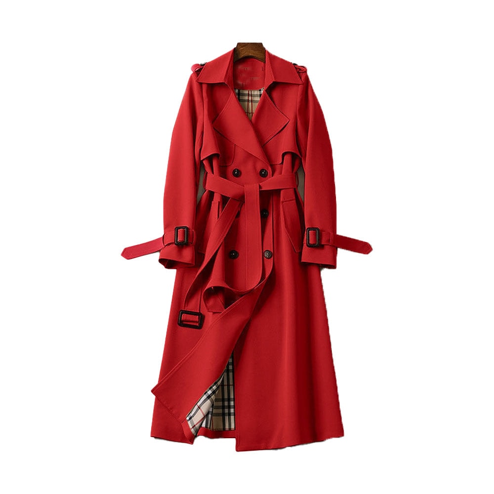 Red long double-breasted trench coat with a tied belt, buckled cuff tabs, shoulder epaulettes, storm flap, and plaid-patterned lining peeking through the open front.
